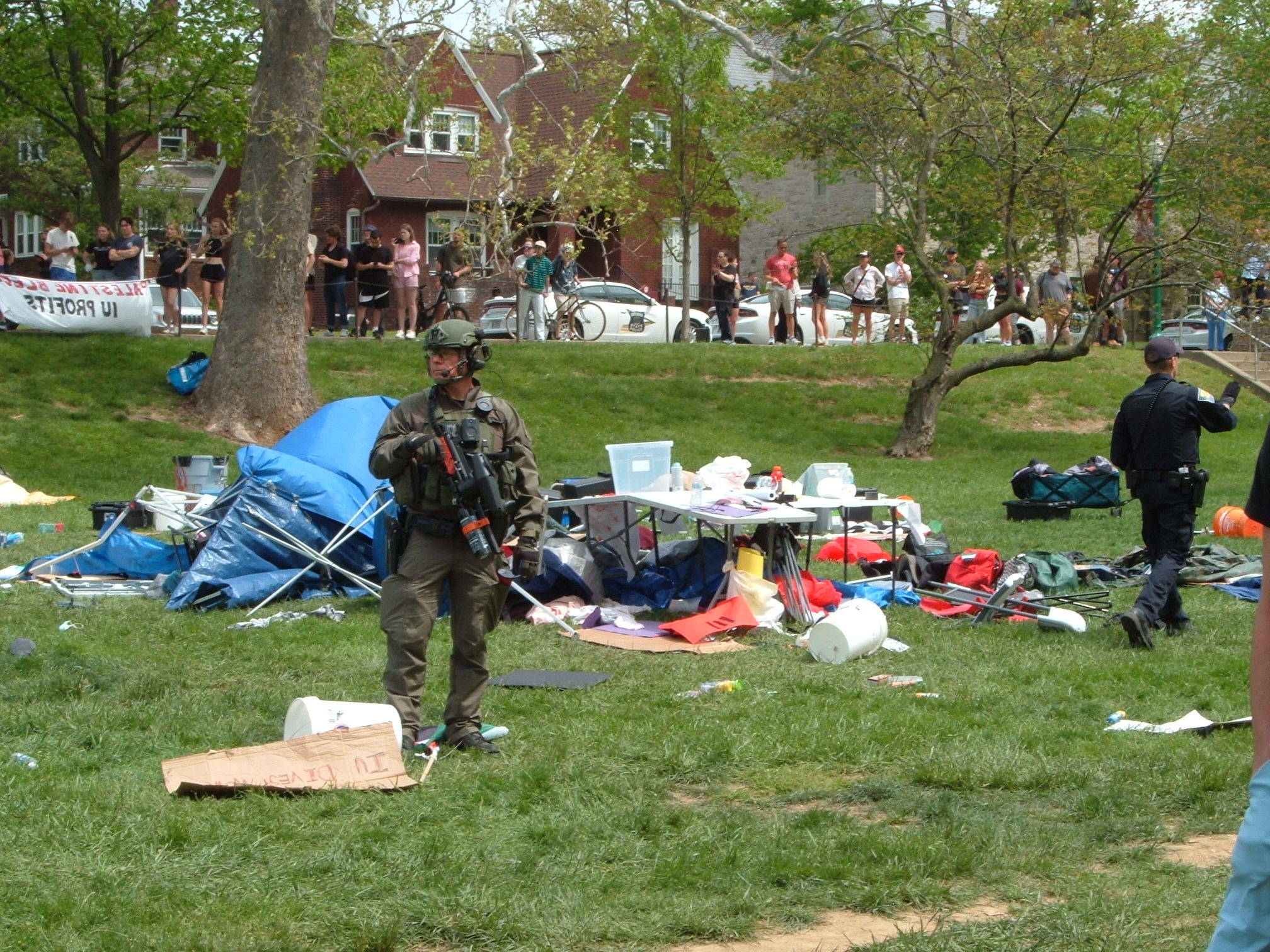 A SWAT officer stands in front of the detritus of the camp destroyed just minutes earlier.